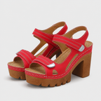 Red platform sandals with chunky block high heels and adjustable hook and loop ankle straps.