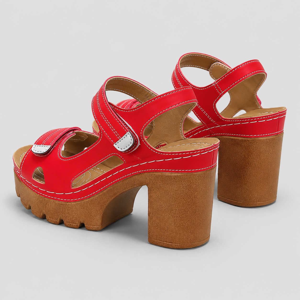 Red sandals with brown platform chunky block high heels and adjustable hook and loop ankle straps.