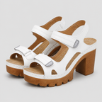 White sandals with brown platform chunky block high heels and adjustable hook and loop ankle straps.