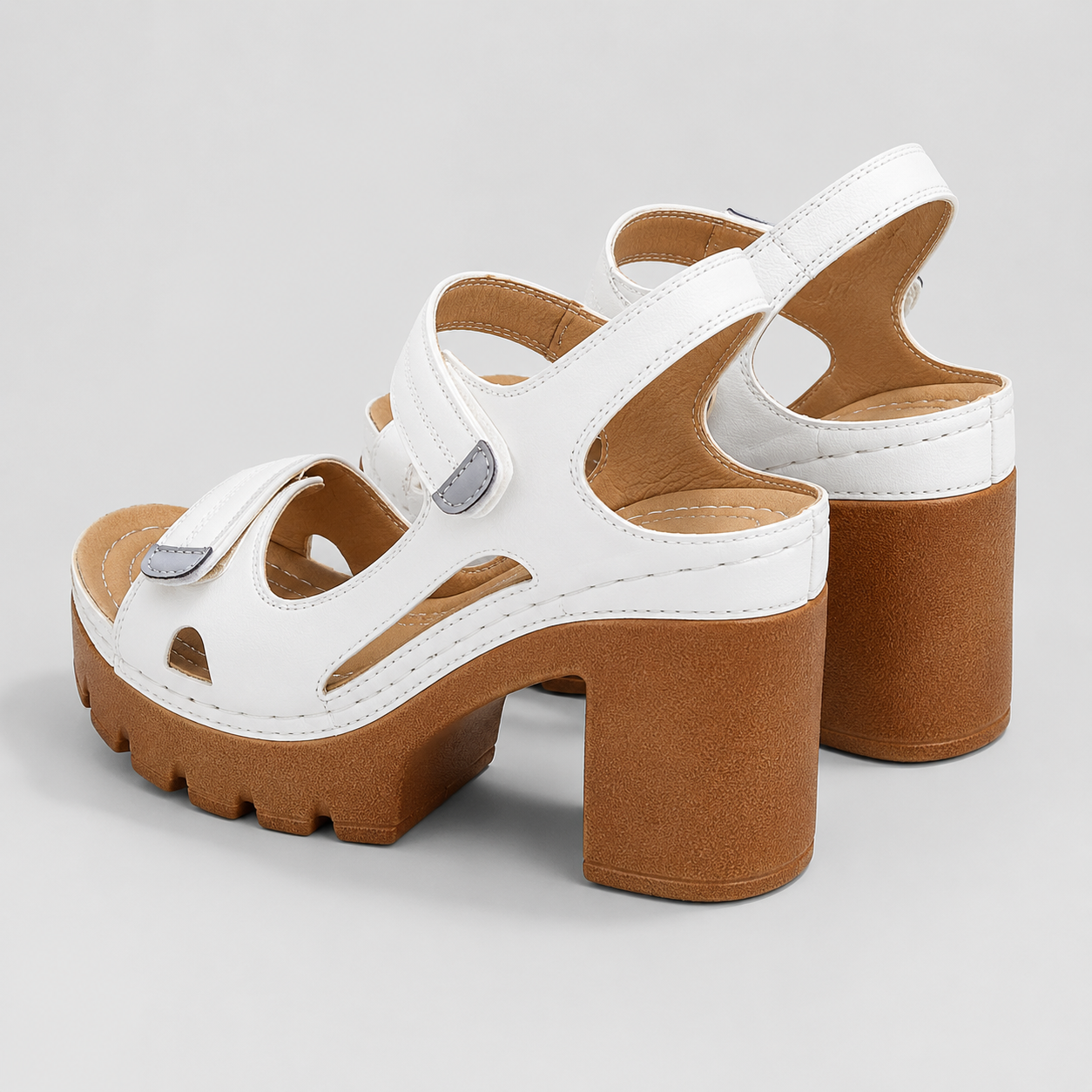 White sandals with brown platform chunky block high heels and adjustable hook and loop ankle straps.