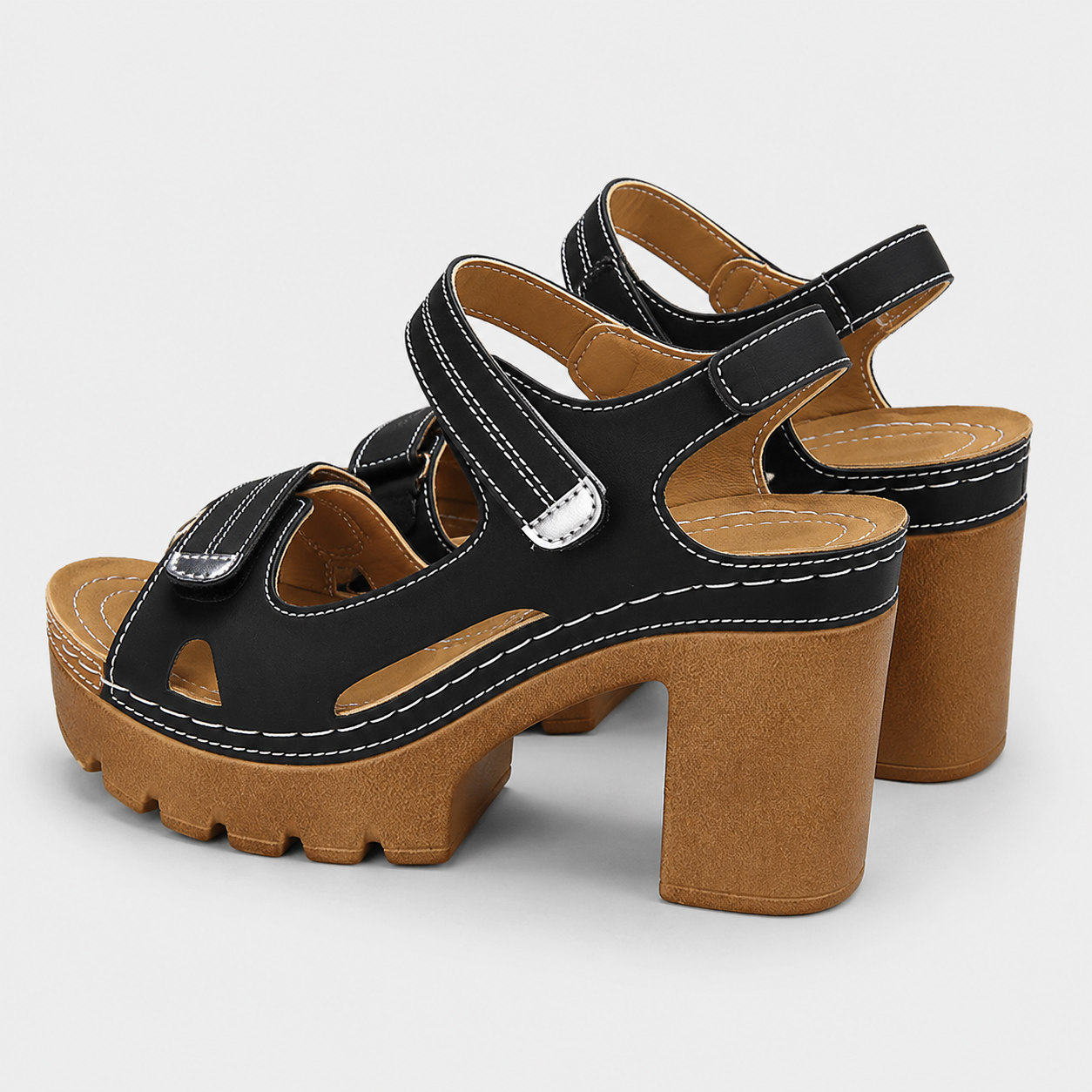 Black and brown platform sandals with chunky block high heels and adjustable hook and loop ankle straps.