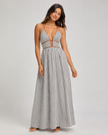 Woman wearing a black and white striped halter maxi dress with a deep plunging V-neckline and contrasting brown fabric trim.